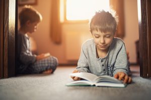 Two brothers reading books in the morning
